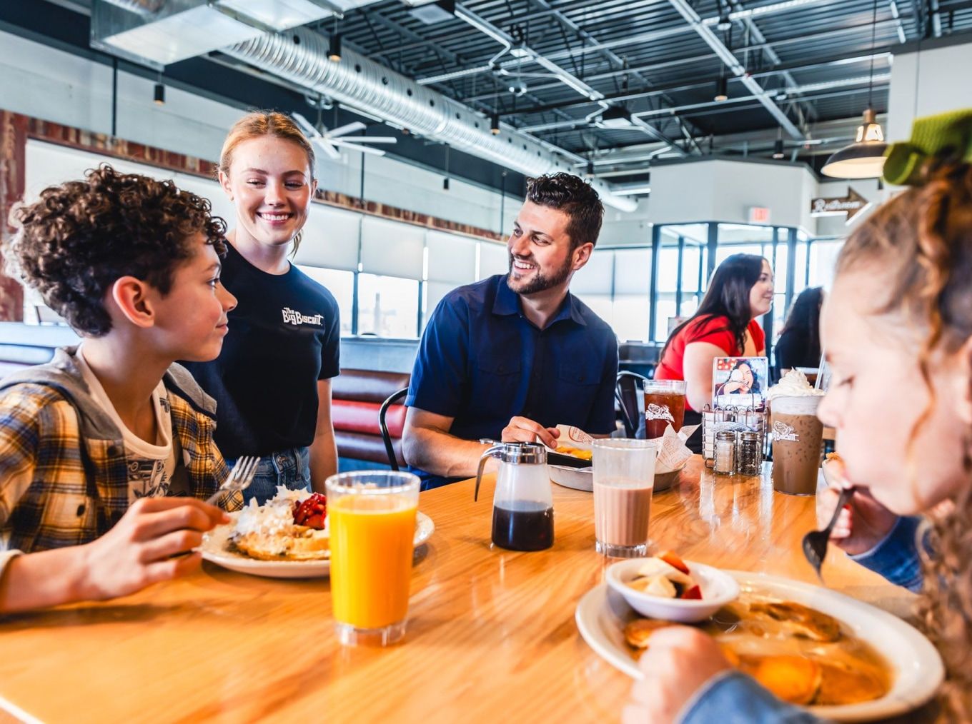 The Big Biscuit server greeting a family at their table