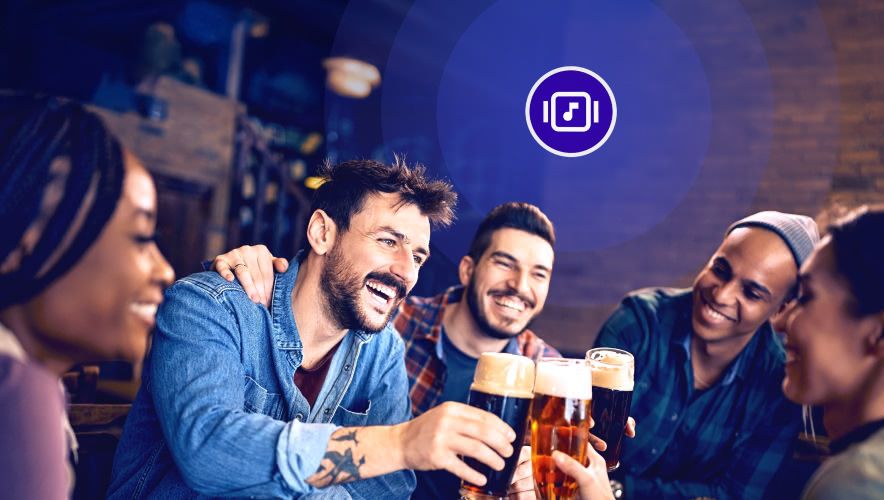 A group clinking glasses in a restaurant with Rockbot Music playing in the background