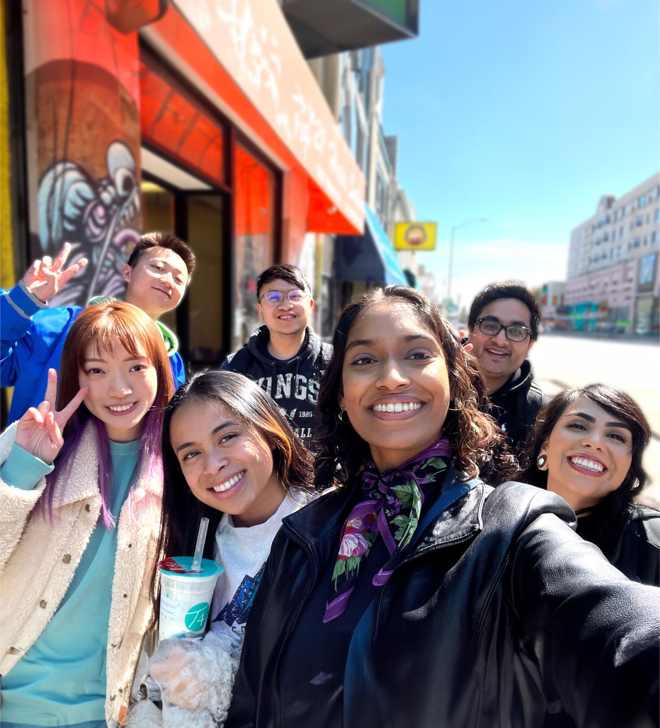 7 people smiling posing for a selfie during an outing.