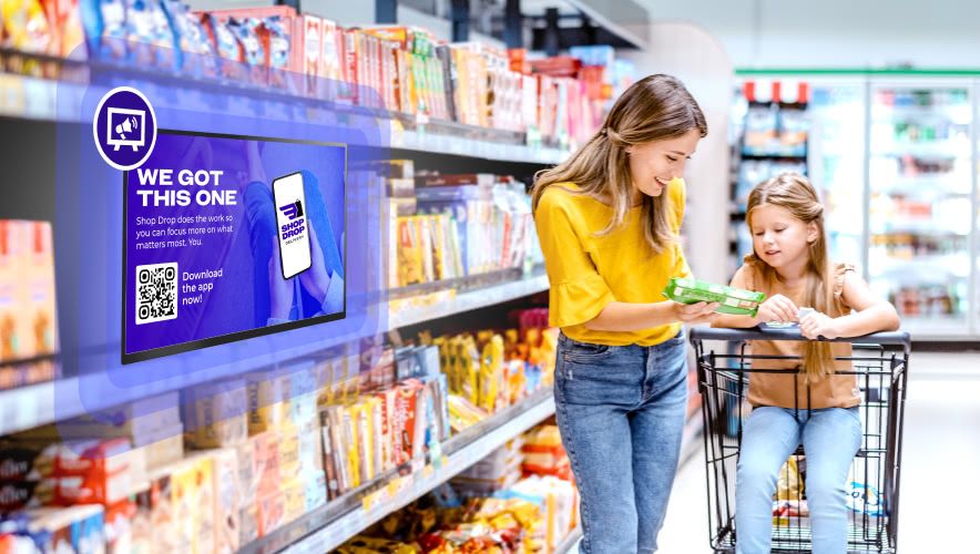 Mother and daughter in a grocery store aisle with a Rockbot Retail Media screen displayed next to them