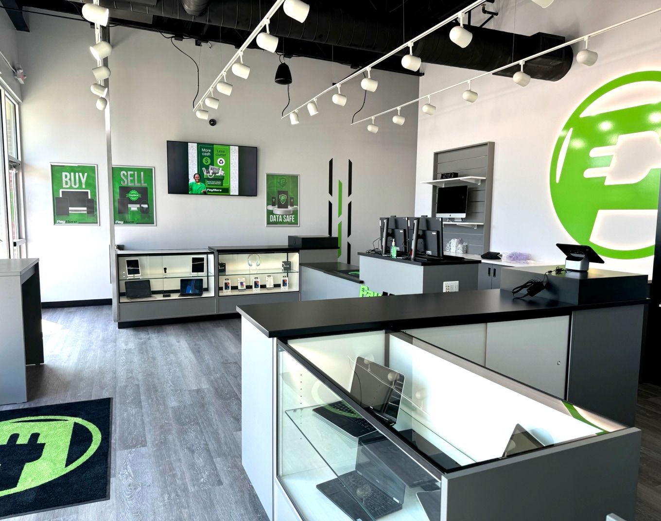 In-store electronics counter at a PayMore location highlighting the retail environment before centralized audio management