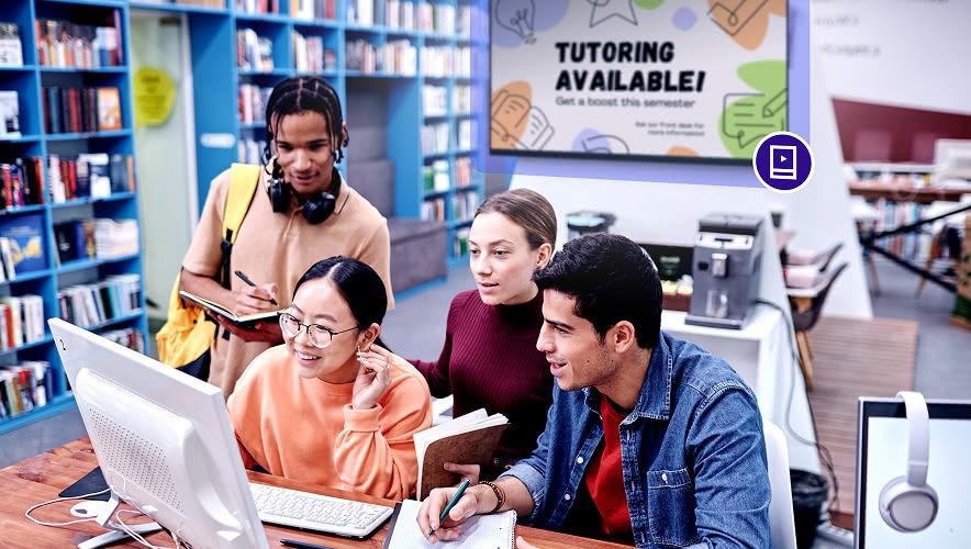 Students in a campus library viewing a tutoring availability display