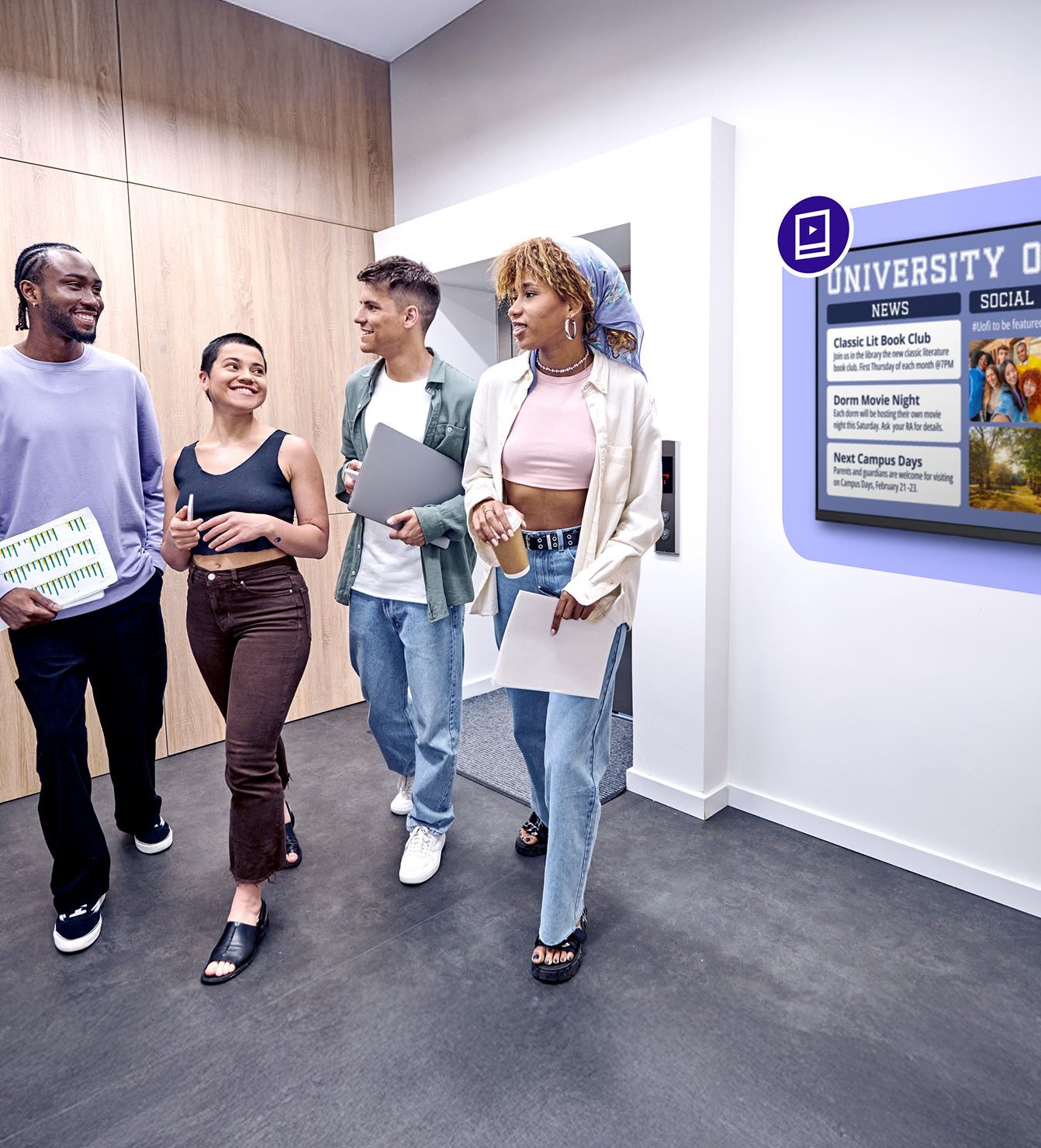 College students walking past a digital signage display in a campus hallway