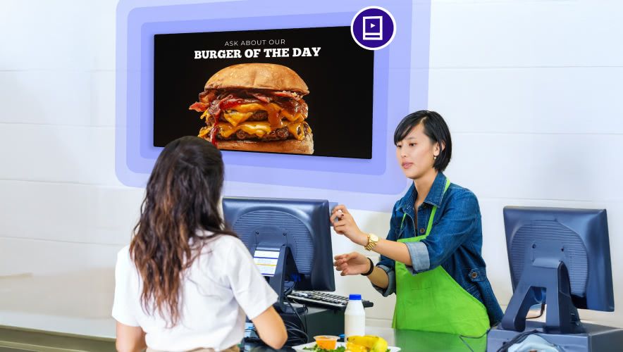 Person ordering food from a counter with Rockbot Digital Signage behind them