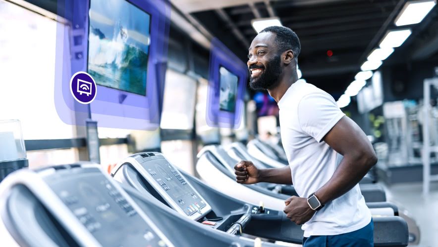 A man running on the treadmill while watching Rockbot TV