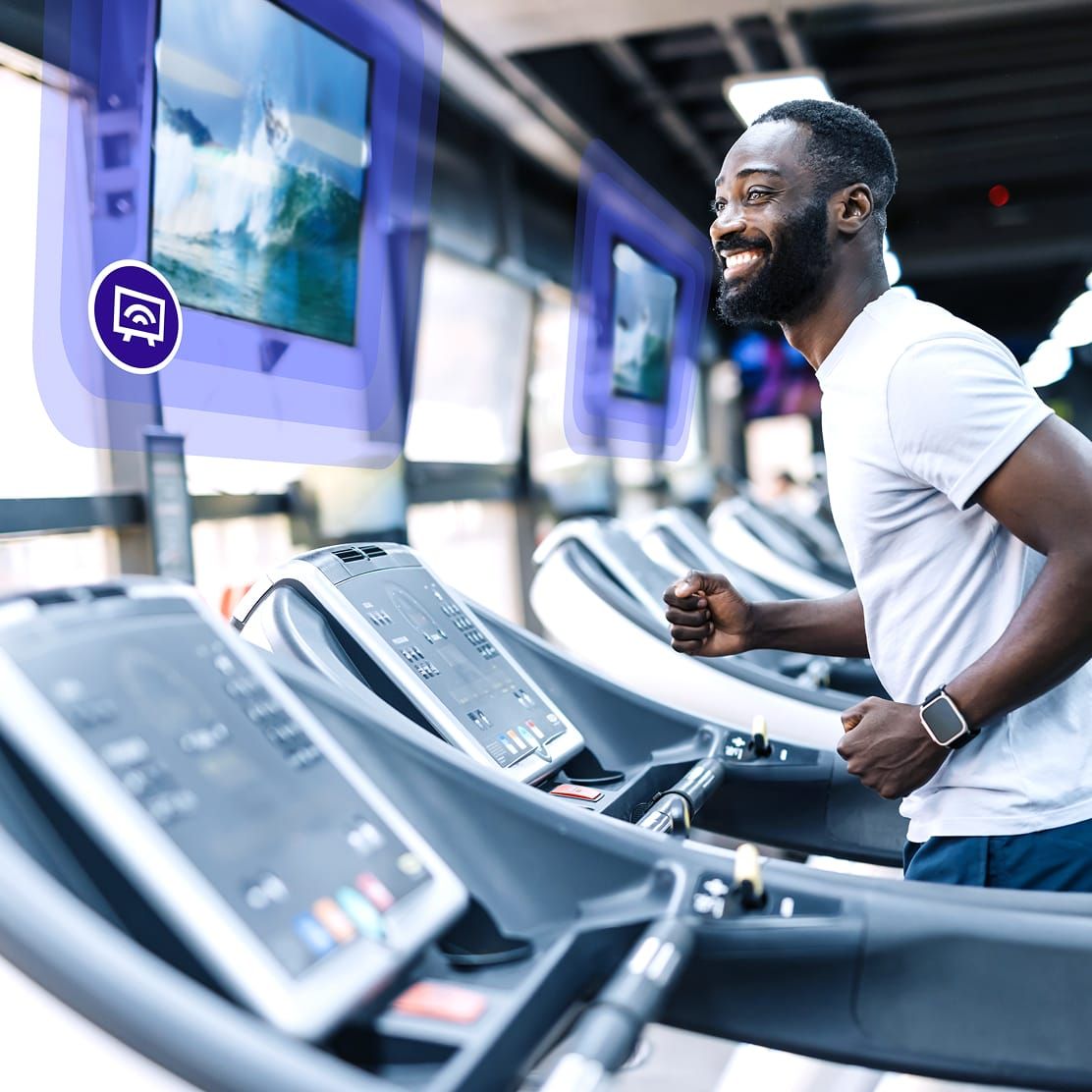Gym member using cardio equipment with Rockbot digital media services