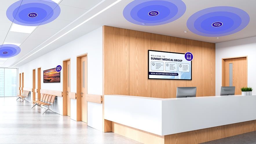 Modern healthcare lobby with coordinated digital screens powered by a unified in-location media platform.