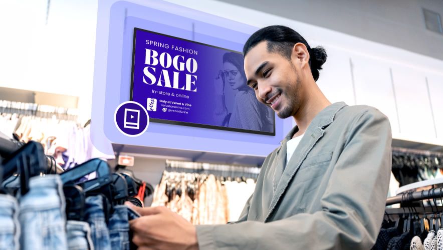 A man shopping for clothes with Rockbot Digital Signage in the background
