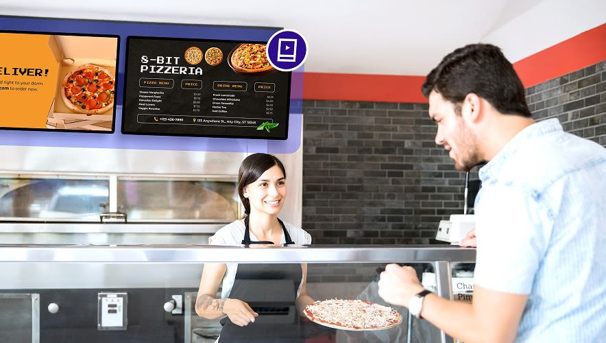 Staff serving food at a university dining hall with a digital menu board