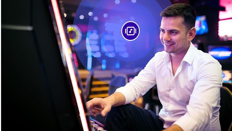 A man playing a slot machine with Rockbot Music playing