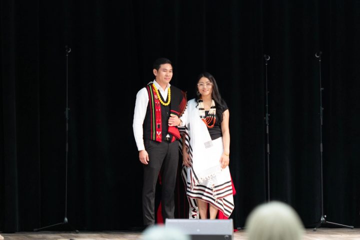 Photograph of two performers posing on stage in traditional dress at the First Naga Baptist Fundraising Cultural Event.