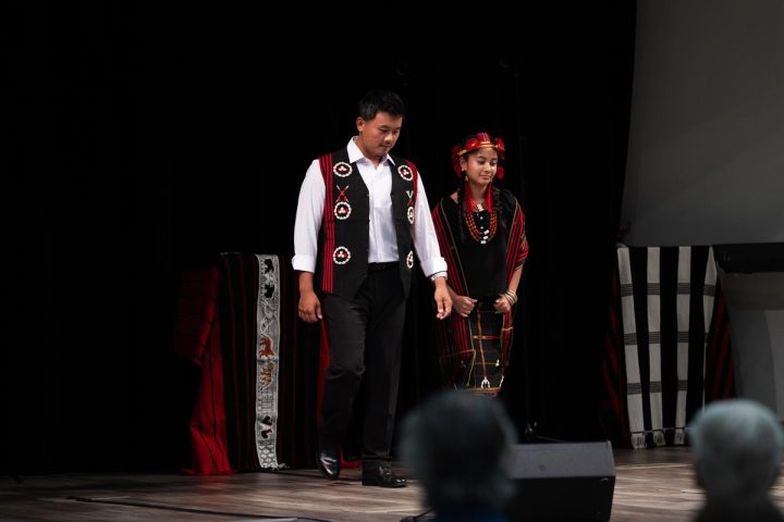 Photograph of two performers standing together on stage at the First Naga Baptist Fundraising Cultural Event.