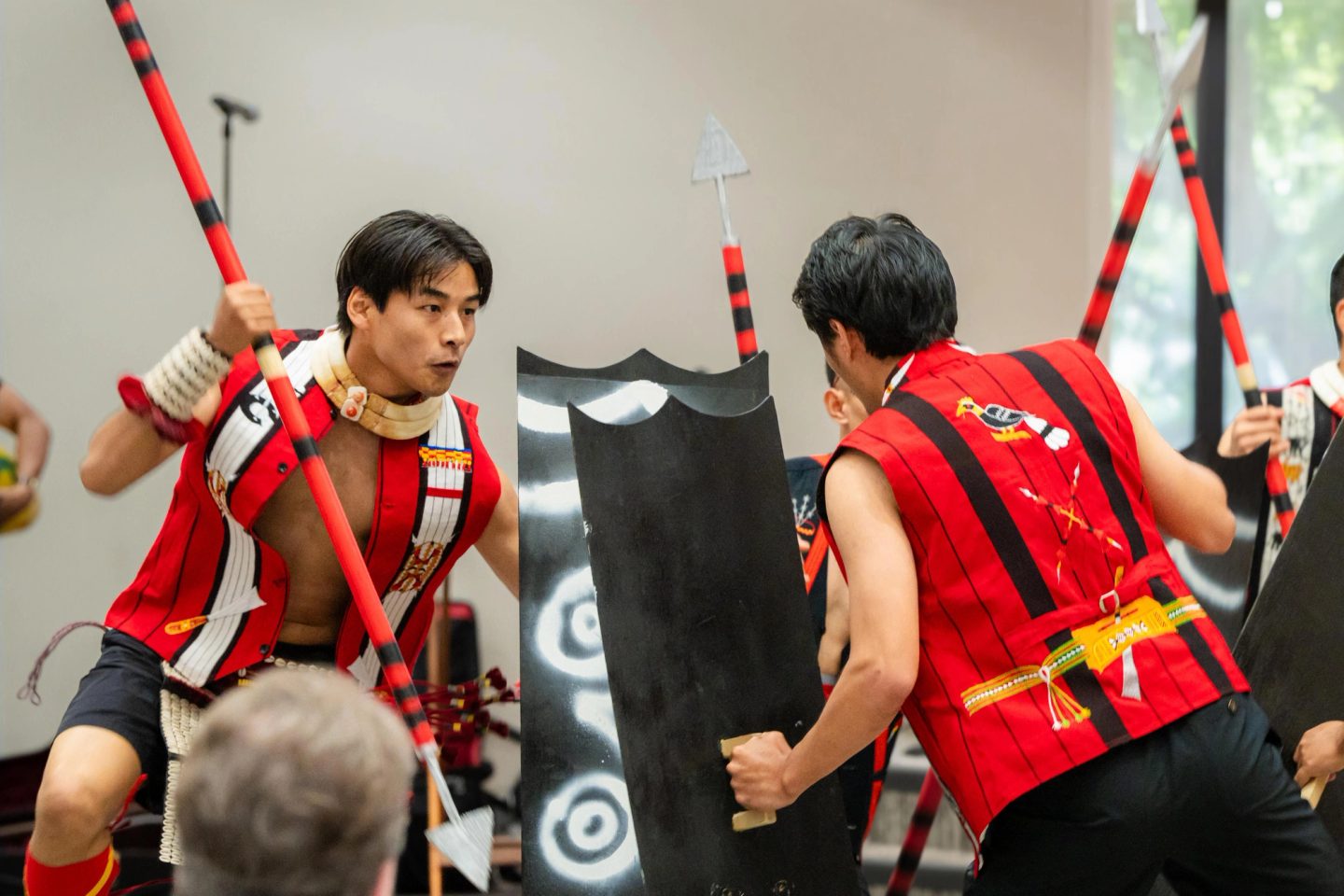 Photograph of performers in traditional Naga attire dancing on stage at the First Naga Baptist Fundraising Cultural Event.