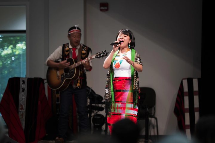 Photograph of a singer performing with a microphone at the First Naga Baptist Fundraising Cultural Event.
