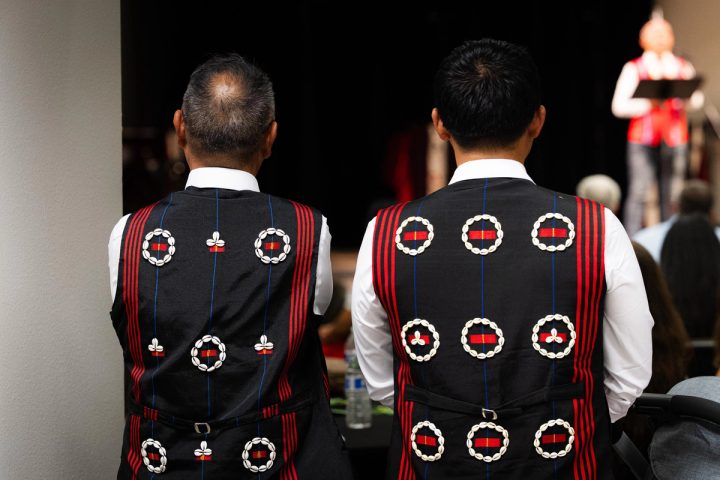 Photograph of two attendees wearing traditional vests viewed from behind at the First Naga Baptist Fundraising Cultural Event.
