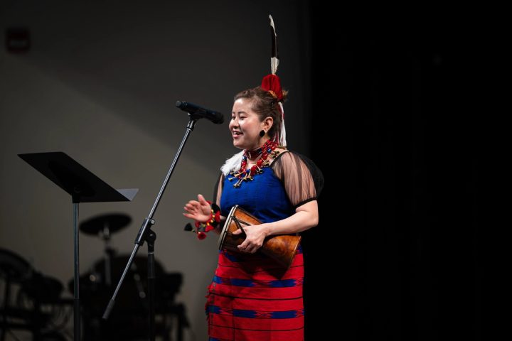 Photograph of a speaker addressing the audience from the stage at the First Naga Baptist Fundraising Cultural Event.