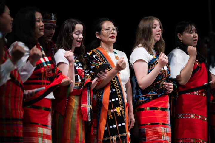 Photograph of women in traditional Naga attire singing on stage at the First Naga Baptist Fundraising Cultural Event.