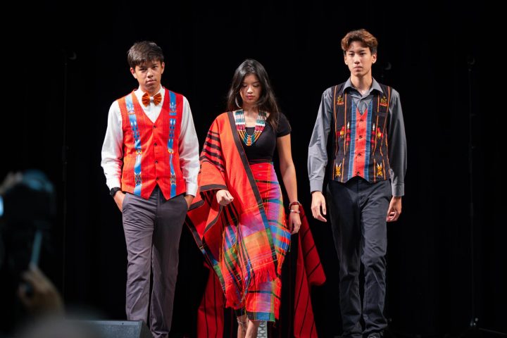 Photograph of three performers in traditional Naga attire standing on stage at the First Naga Baptist Fundraising Cultural Event.