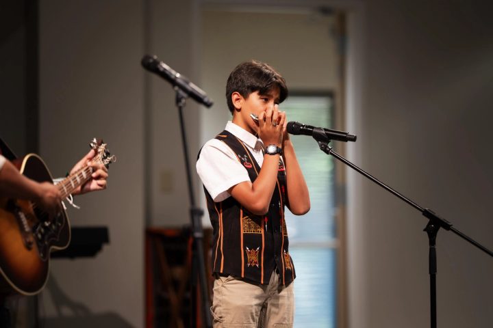 Photograph of a vocalist singing into a microphone at the First Naga Baptist Fundraising Cultural Event.