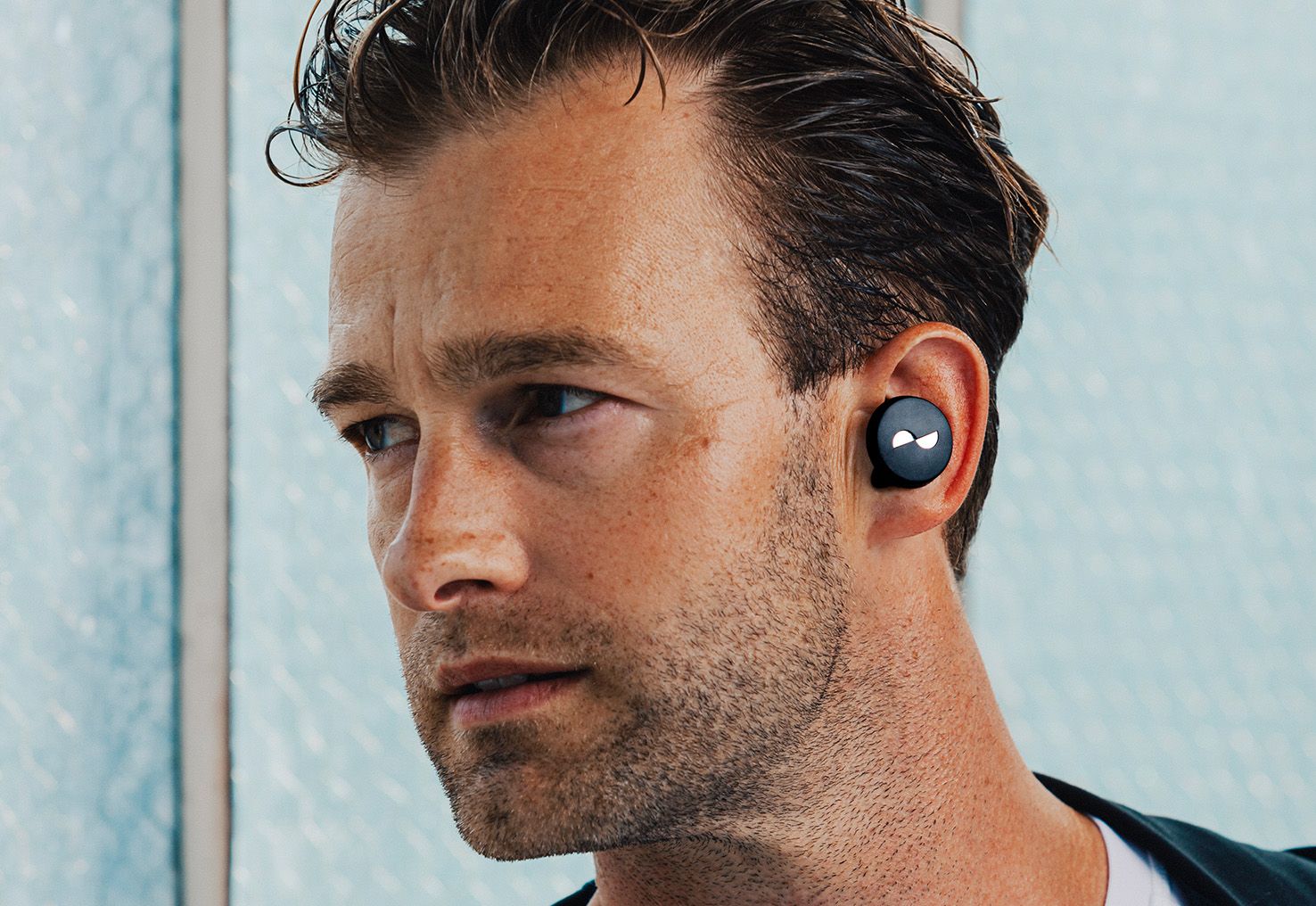 Person covered in sweat with NURATRUE earbuds in ears