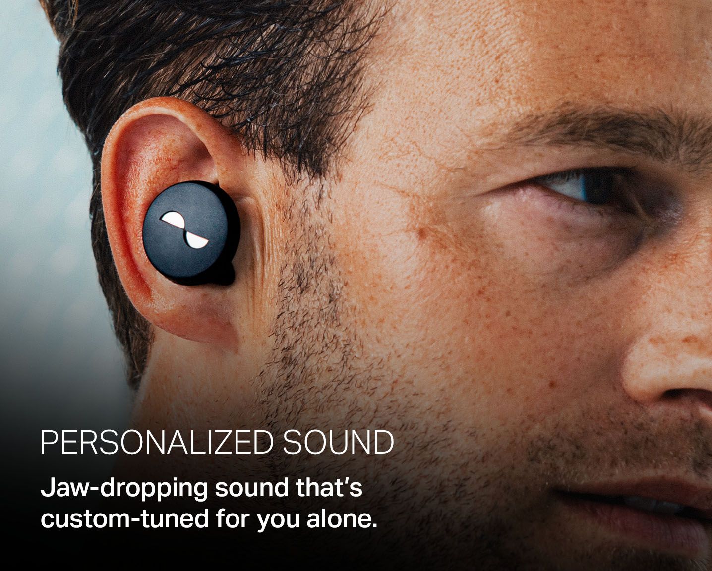 Person wearing the NURATRUE earbuds in ears, with overlay text: "Personalized sound. Jaw-dropping sound that's custom-tuned for you alone."