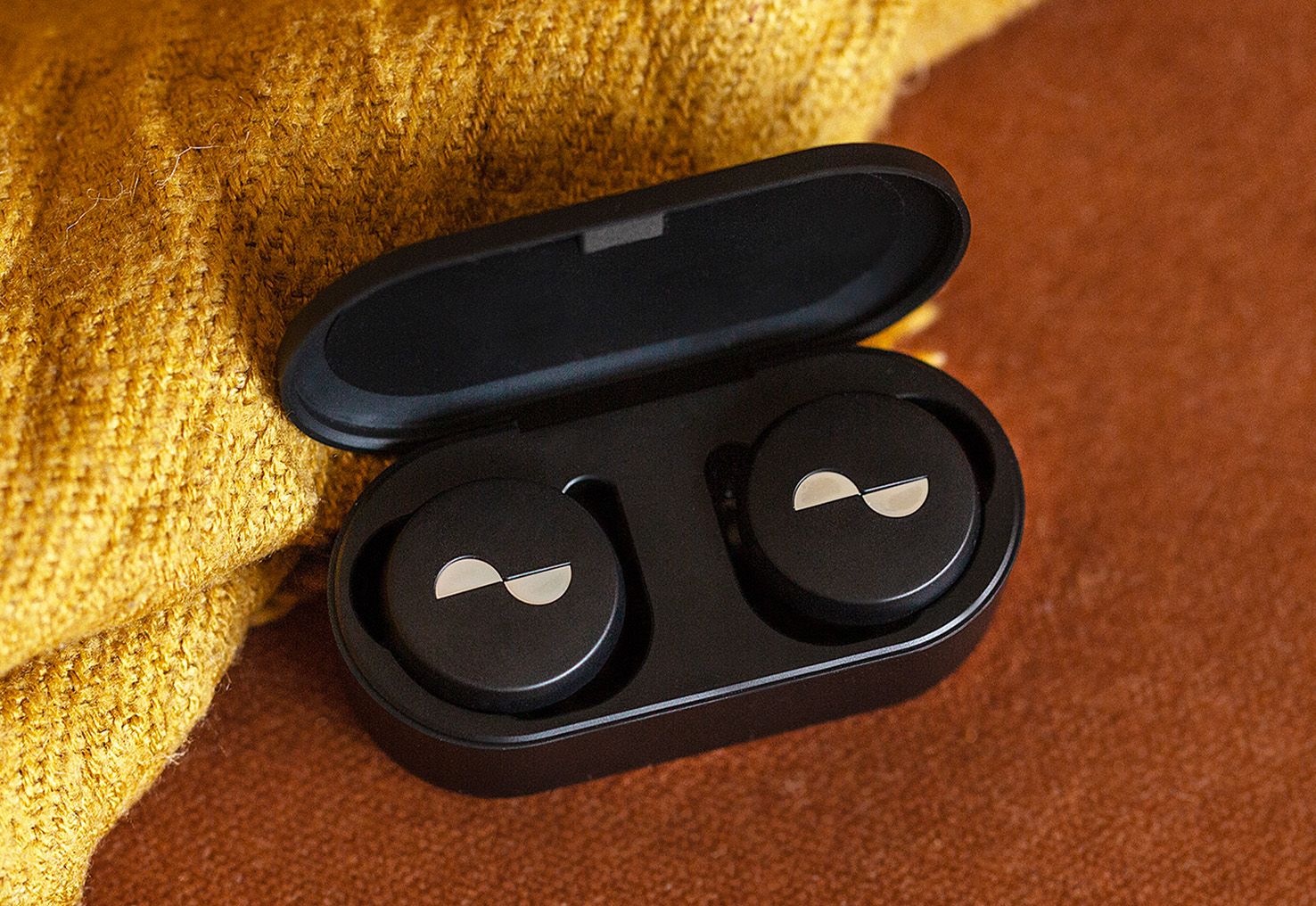 Angled shot of NURATRUE earbuds in battery case