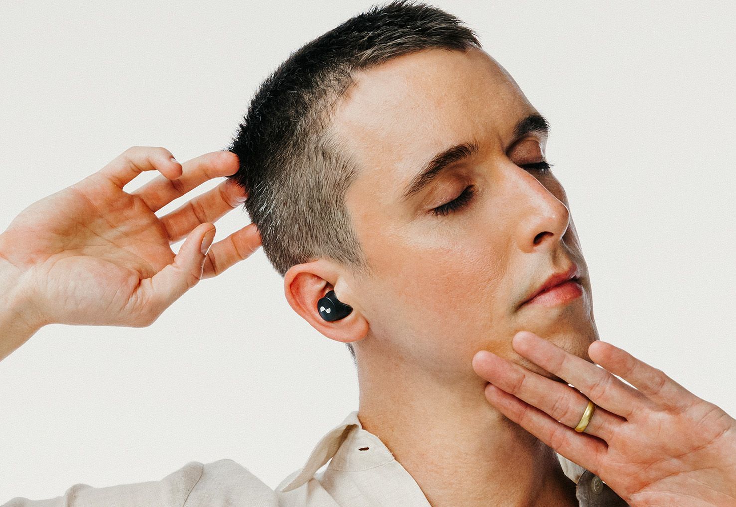 Person with eyes closed with NURABUDS earbuds in ears