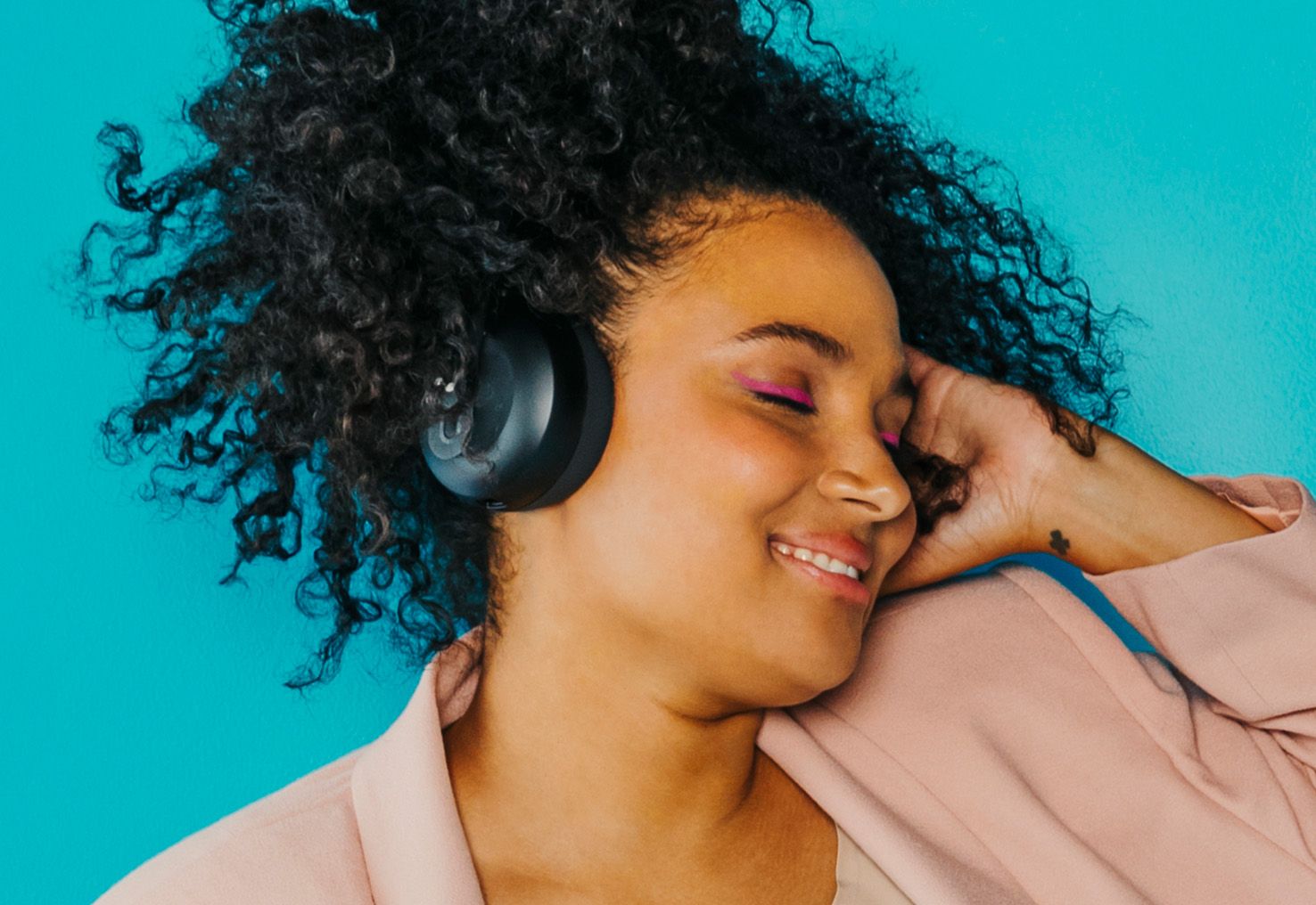 Person with eyes closed with NURAPHONE headphones on listening to sound