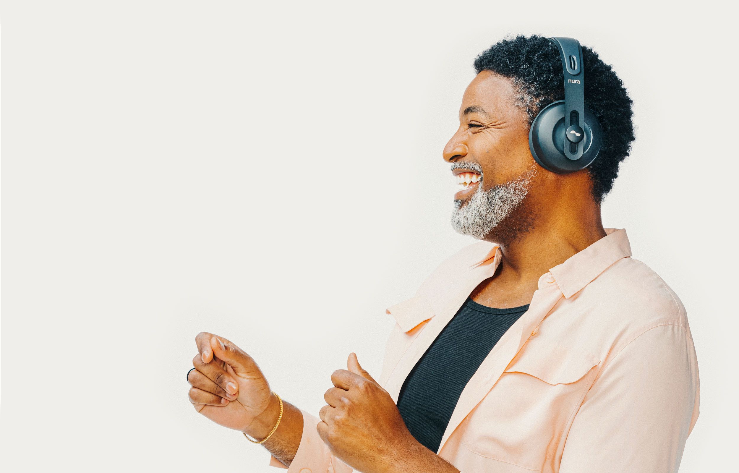 Person laughing and dancing with NURAPHONE headphones on ears