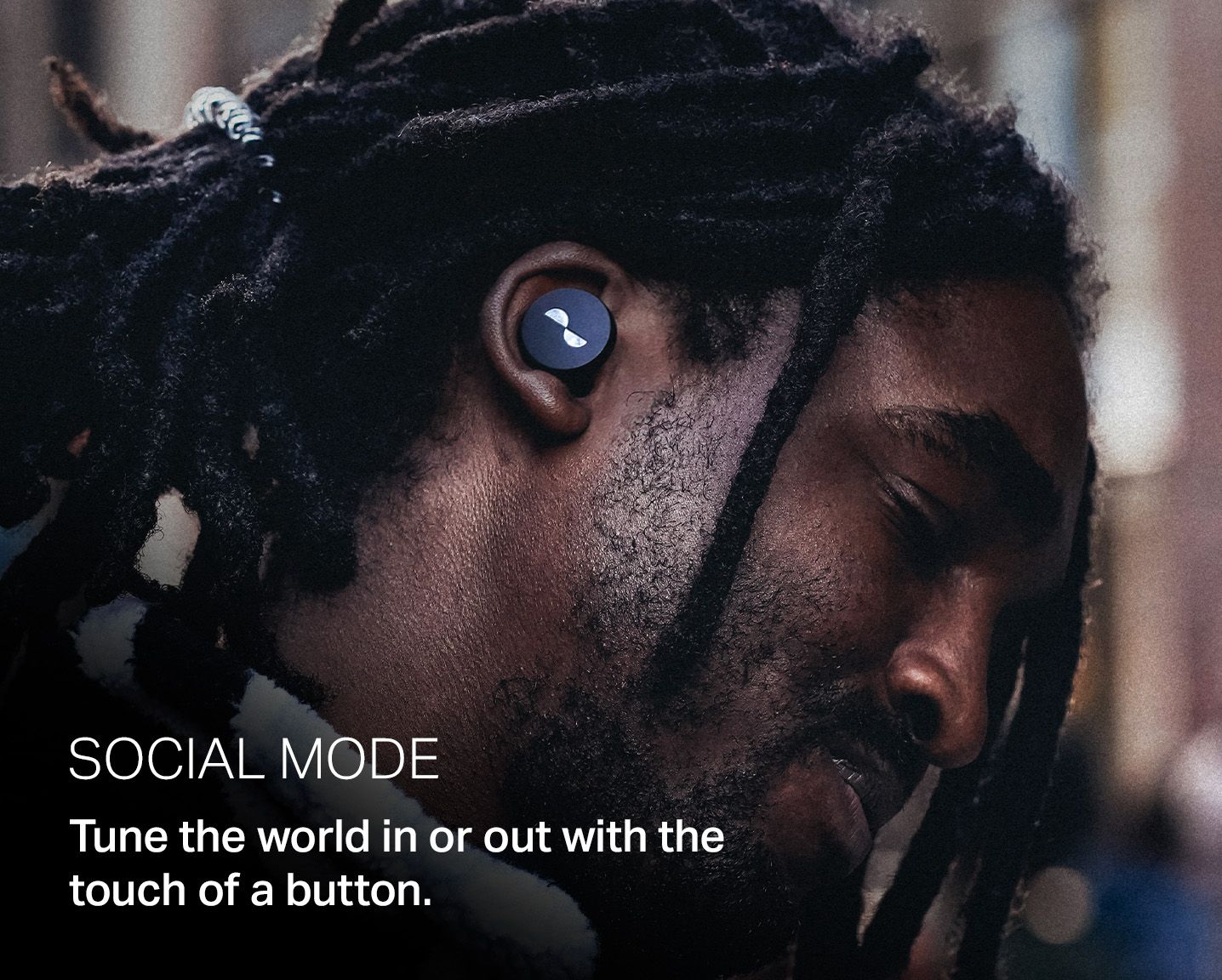 Person wearing the NURATRUE earbuds in ears, with overlay text: "Social mode. Tune the world in or out with the touch of a button."