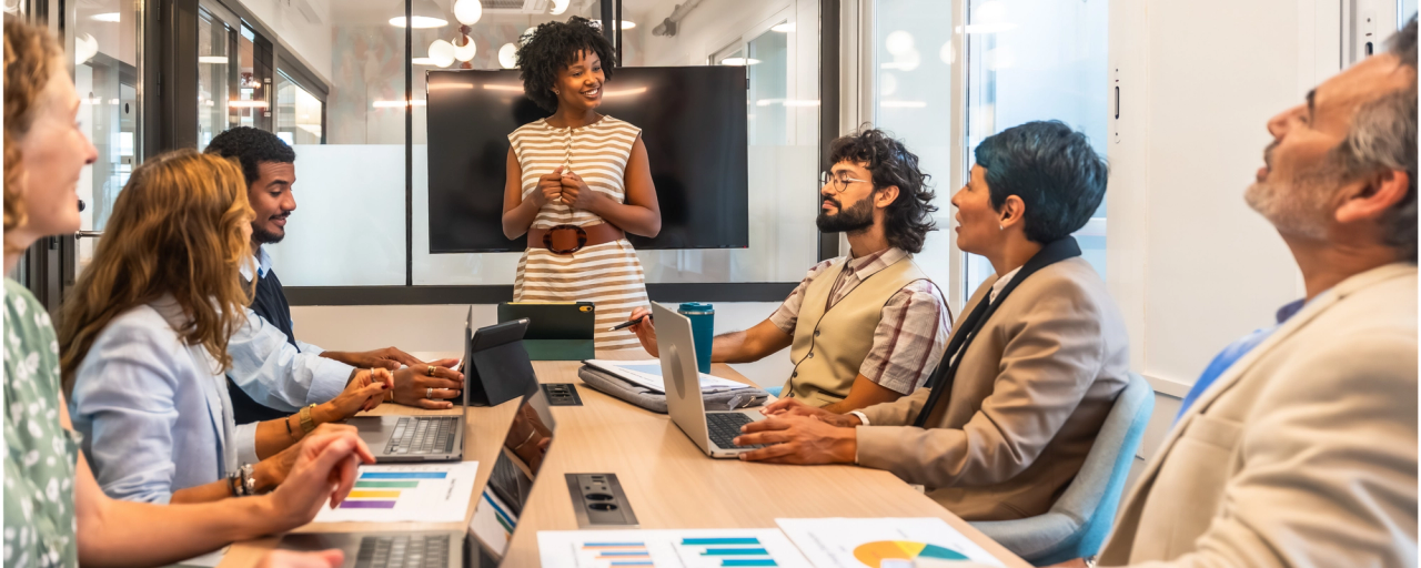 seven colleagues in a discussion with one person leading it