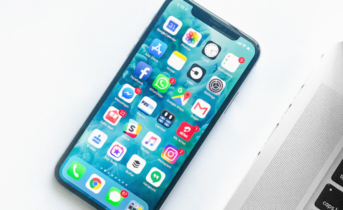 A phone home screen crowded with apps beside a single messenger app holding several chatbots instead
