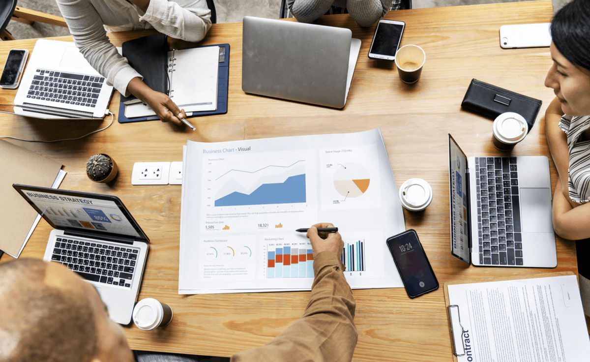 A team reviewing printed business charts and dashboards across a shared desk