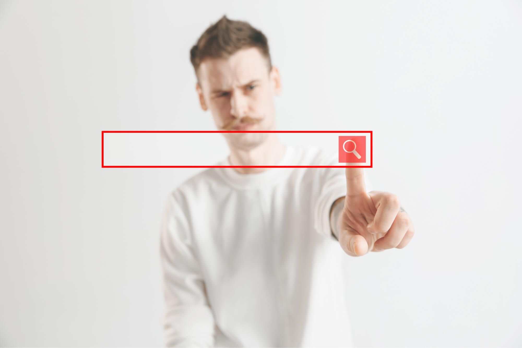 Man touching an empty search bar with a magnifying-glass icon, representing an SEO search query