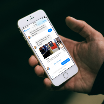 A hand holding an iPhone showing a Facebook Messenger chatbot conversation, the bot answering with product photos and a blue call-to-action button