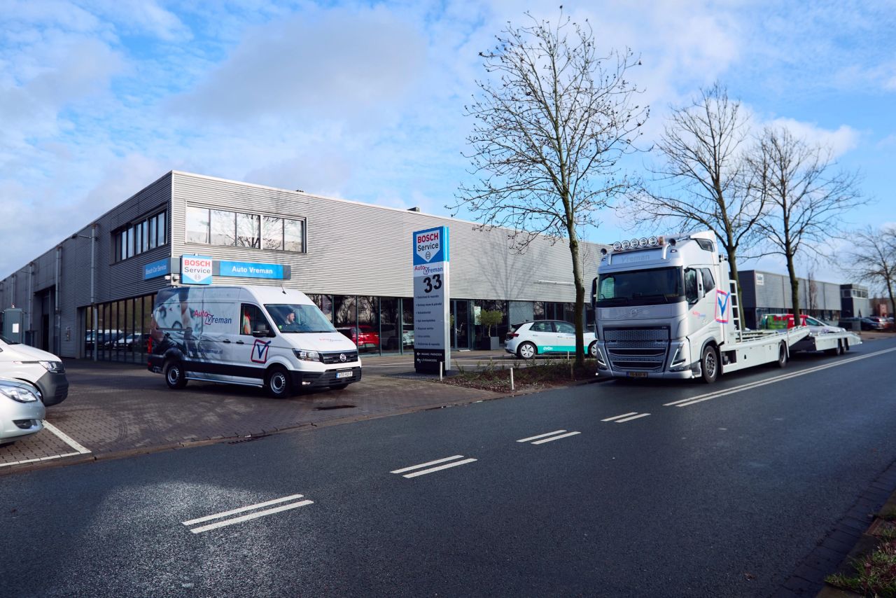 Bedrijfspand van Auto Vreman met een bestelbus op de weg ervoor.