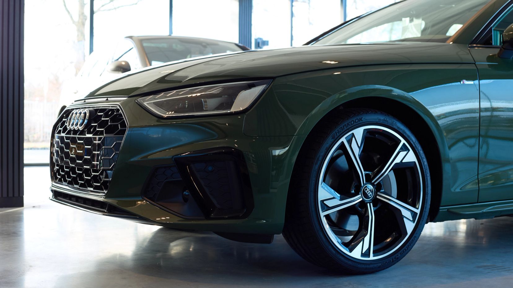 Donkergroene sportieve auto in de showroom van Auto Vreman.