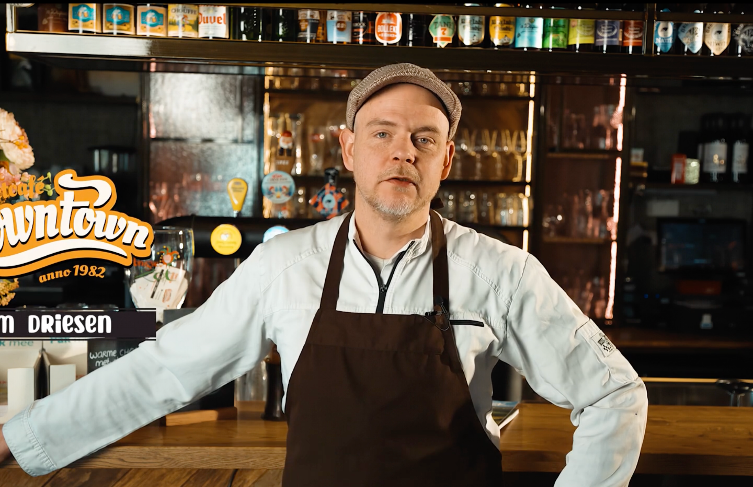 Barman met pet en schort achter de bar van een café, gemaakt door Bold Productions