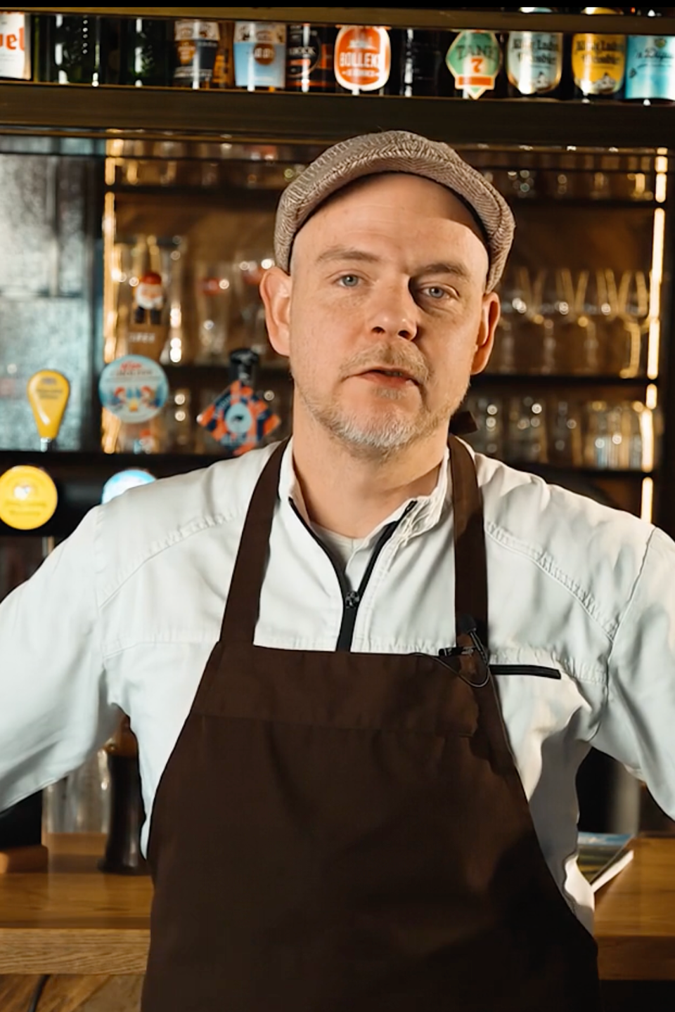 Barman met pet en schort achter de bar van een café, gemaakt door Bold Productions