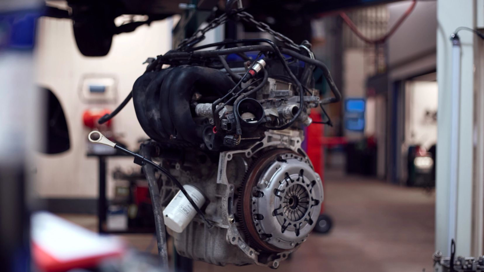 Auto-motor hangt aan de hijsinstallatie in de werkplaats.