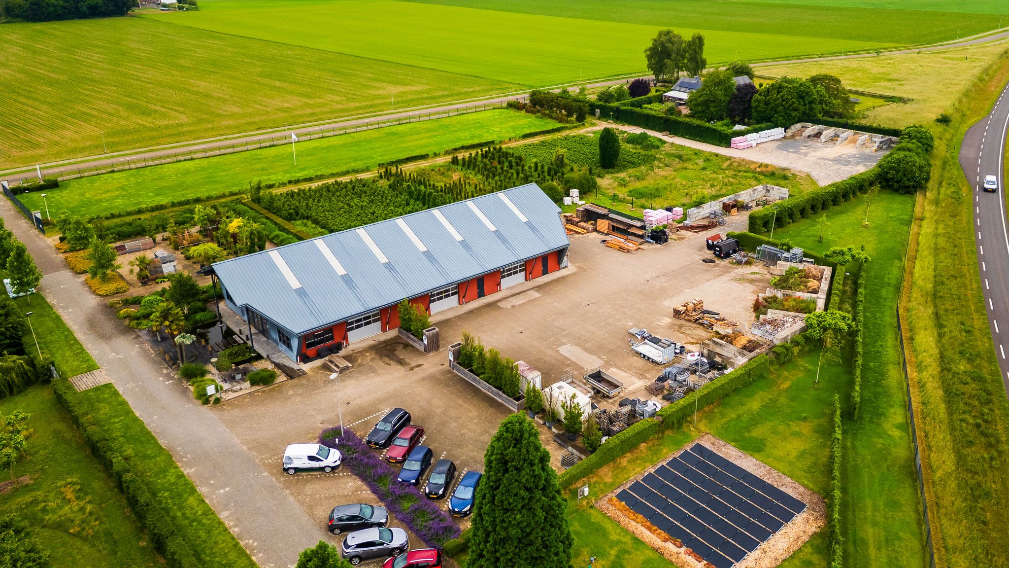 Luchtfoto van het bedrijfspand met parkeerplaats en groene omgeving, gemaakt door Bold Productions