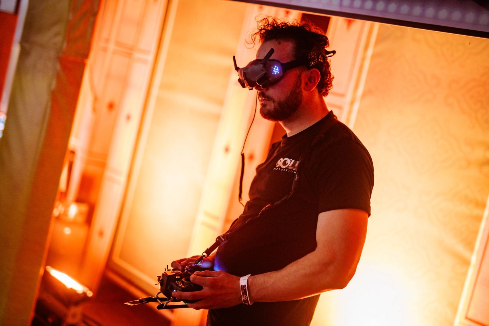 Dronepiloot van Bold Productions met FPV-bril in oranje licht.