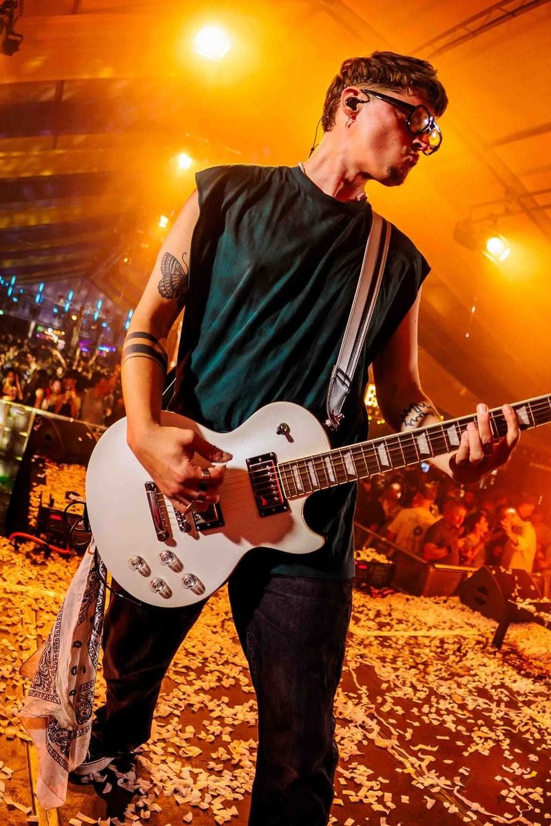 Foto van een gitarist tijdens een live-optreden.