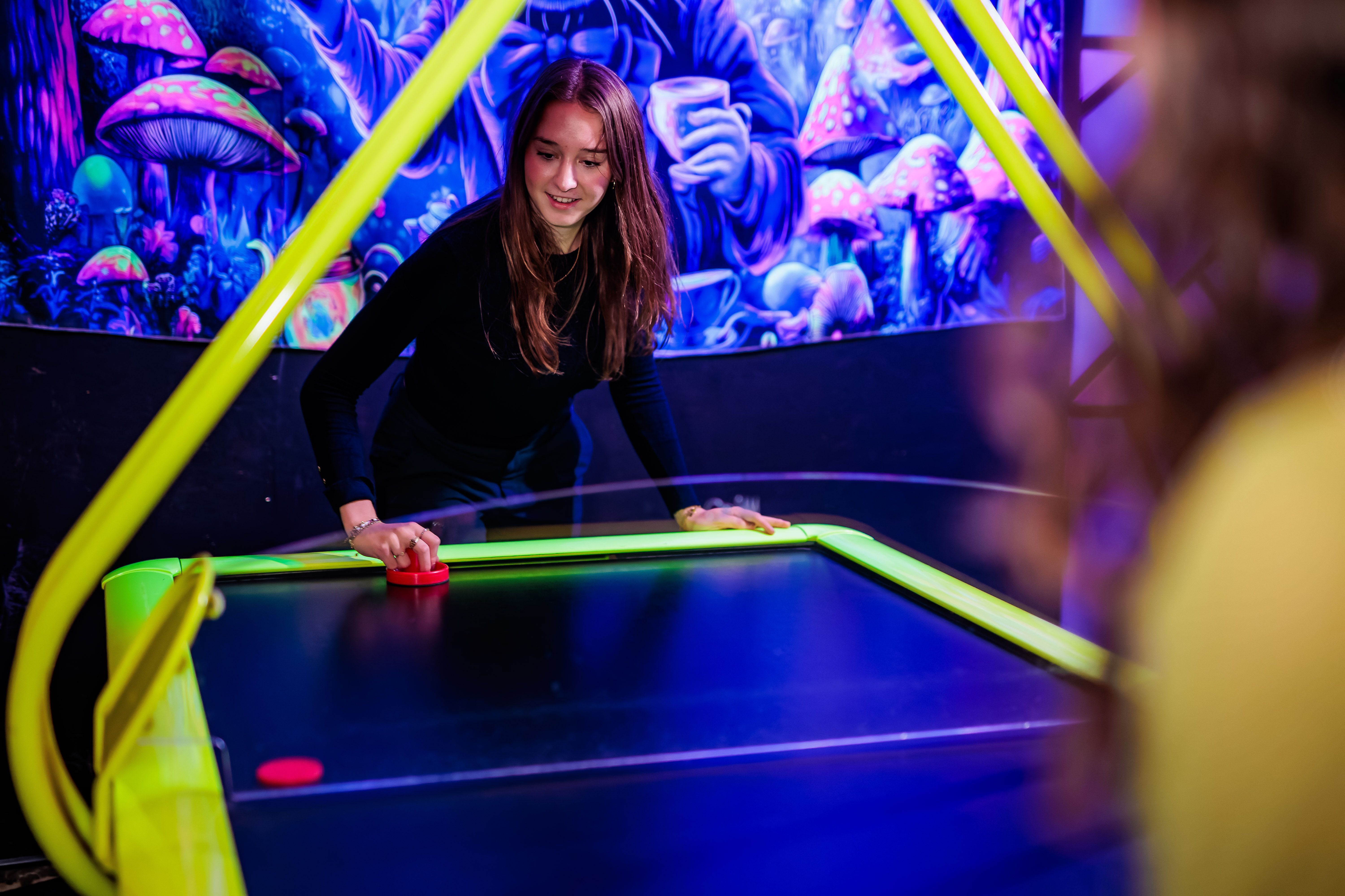 Gast concentreert zich op een potje airhockey bij Timestamp Arnhem.