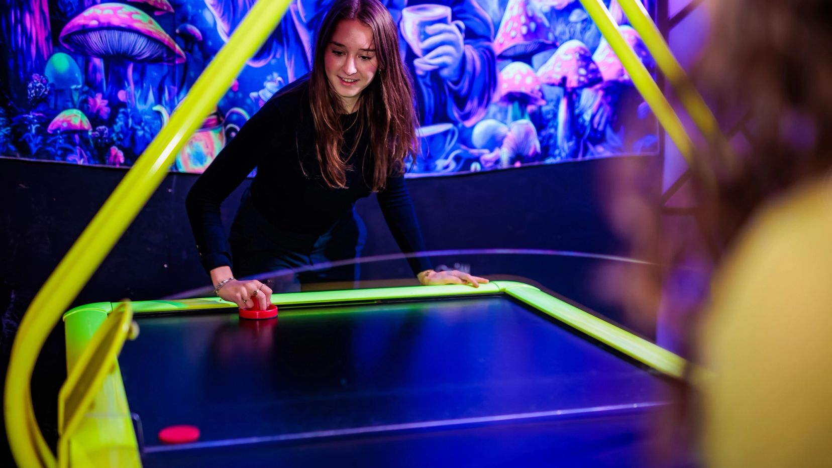 Gast concentreert zich op een potje airhockey bij Timestamp Arnhem.