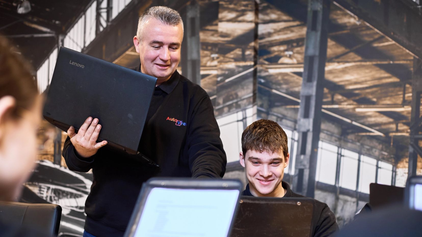 Collega houdt een laptop vast tijdens het overleg met zijn team, gemaakt door Bold Productions