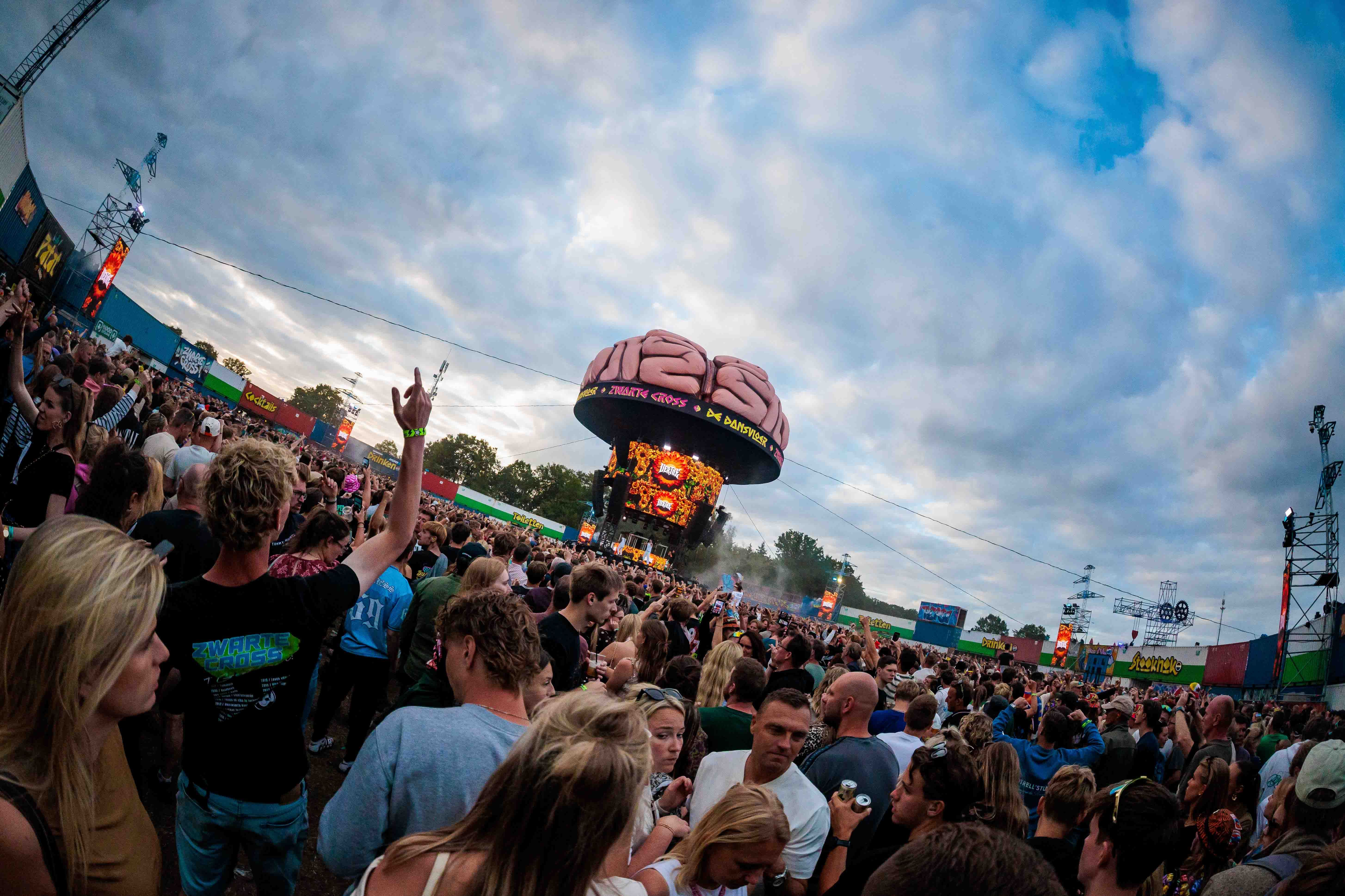 Breedbeeldopname van een groot publiek onder een wolkenlucht, met een luchtballonvormige attractie op de achtergrond, gemaakt door Bold Productions