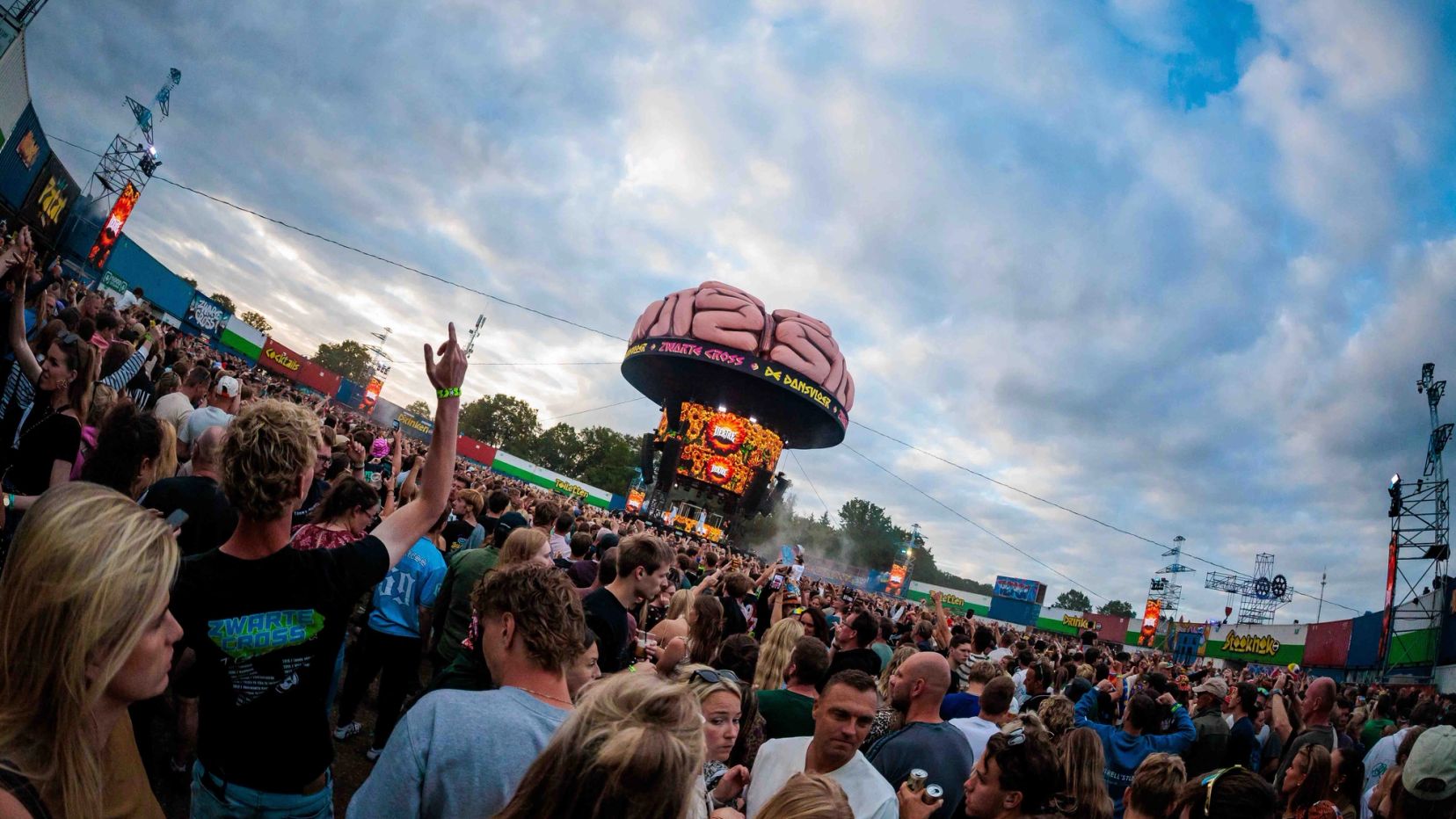 Breedbeeldopname van een groot publiek onder een wolkenlucht, met een luchtballonvormige attractie op de achtergrond, gemaakt door Bold Productions