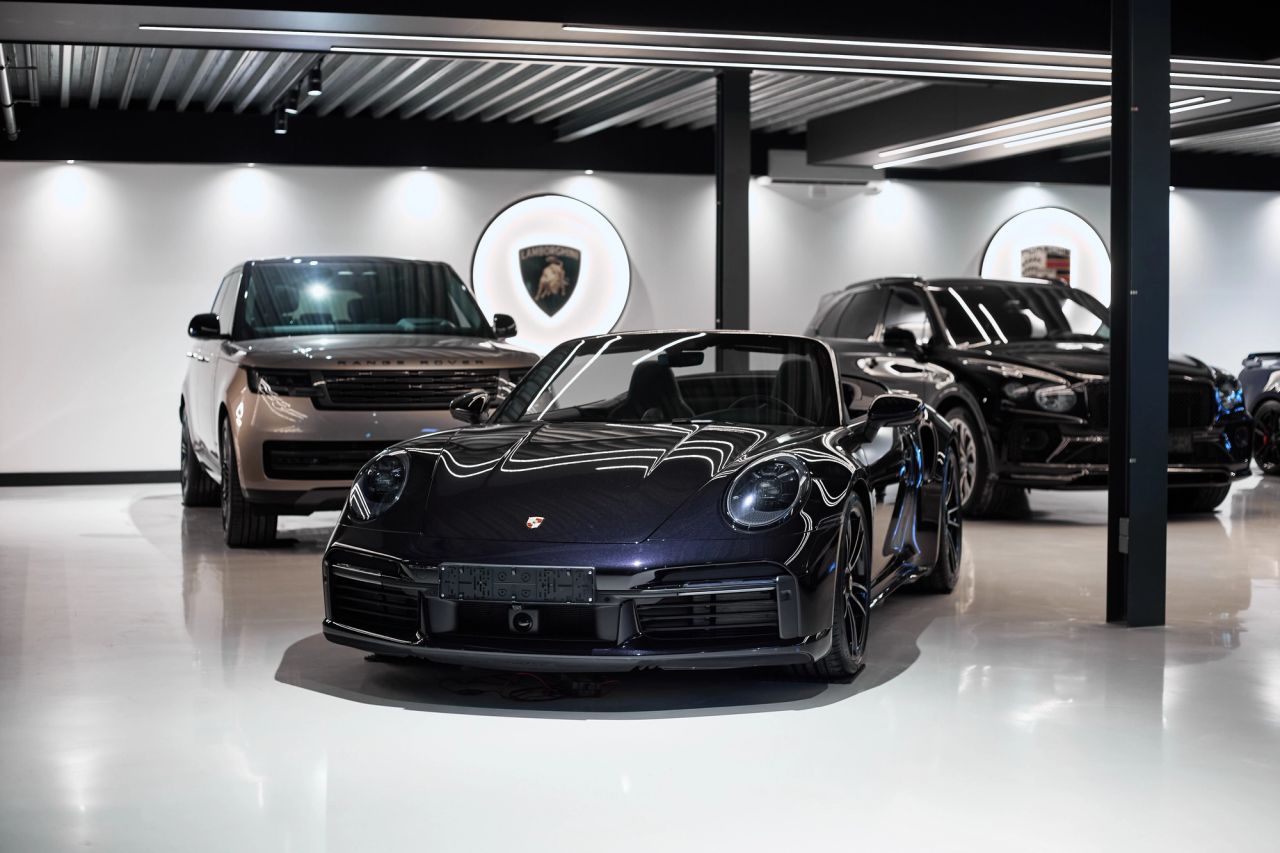 Auto's in de showroom van Auto Vreman, met een paarse cabrio op de voorgrond.
