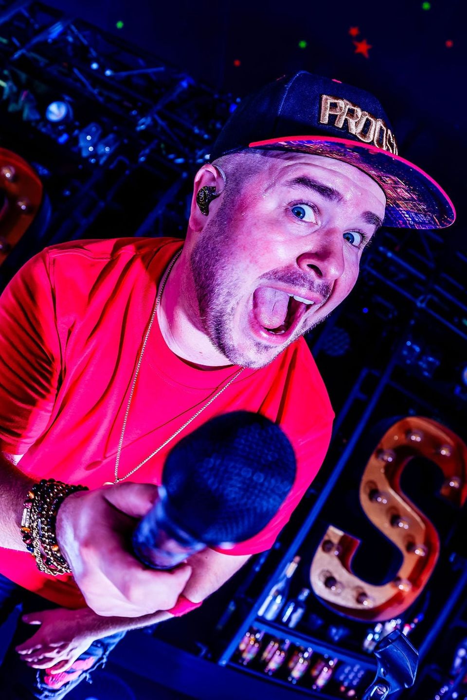 Zanger in een rood shirt met microfoon voor de lichtgevende letters van PROOST!, gemaakt door Bold Productions